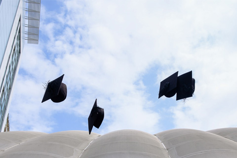 Graduation caps in the air above Richmond Building having been thrown up by graduates.