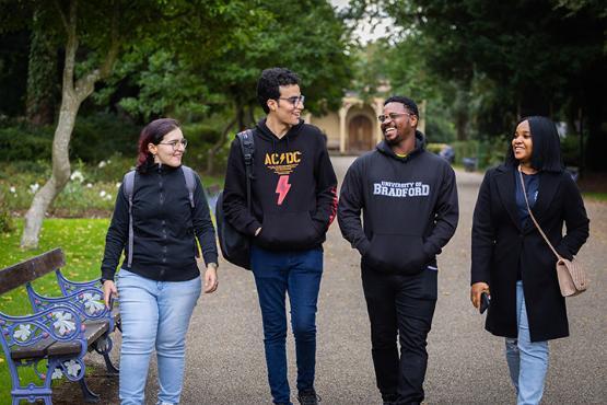 Four students walking along the canal in Saltaire