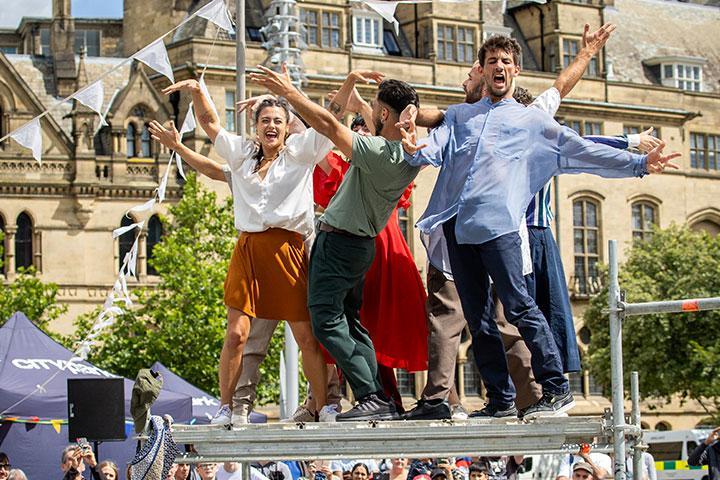 Performers in City Square surrounded by a crowd.