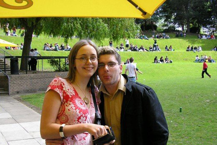 Two students standing on campus with The Amp in the background at University of Bradford