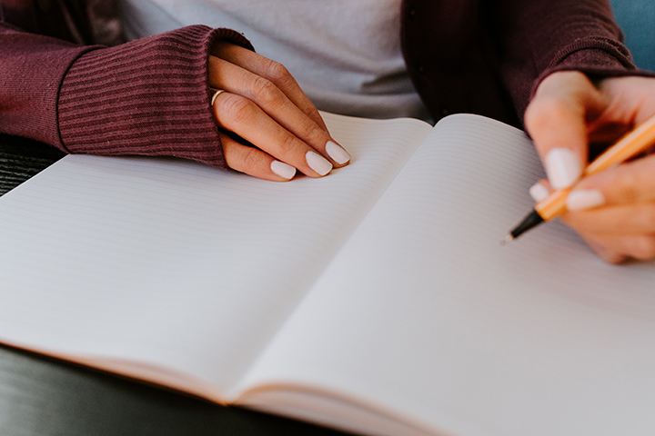 A person writing in a notebook