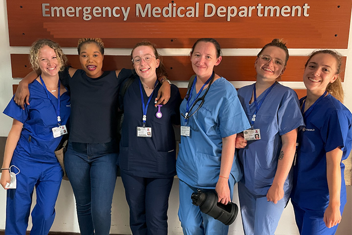 Student nurses wearing their uniforms smiling at the camera