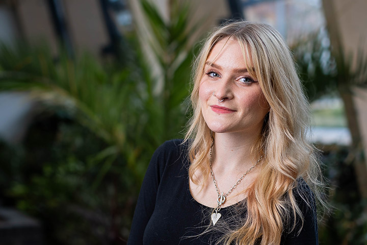 Molly, Public Health and Community Wellbeing student, posing in a room in Bright Building.