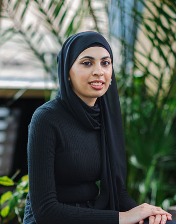 A student sitting and smiling at the camera