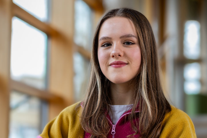 A student standing and smiling at the camera