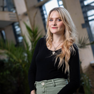 A student smiling at the camera, standing in the Bright building at University of Bradford