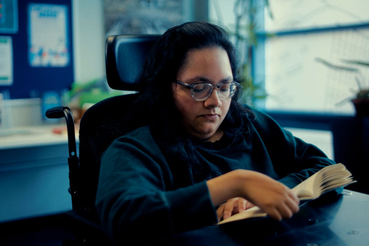 A student sitting at a table reading a book