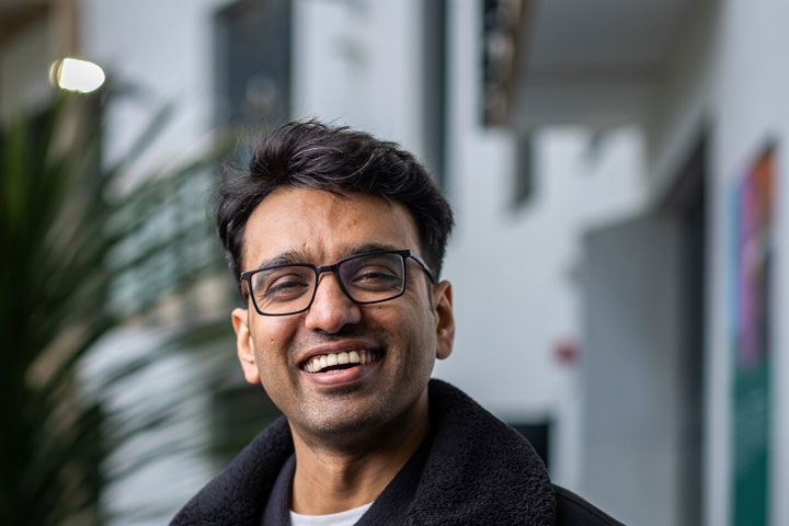 A student smiling at the camera in an atrium