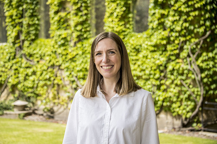 University of Bradford Associate Director of Sustainability stood in front of greenery