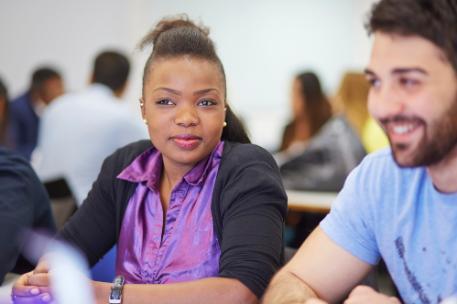 Student in bright purple shirt sat in lecture