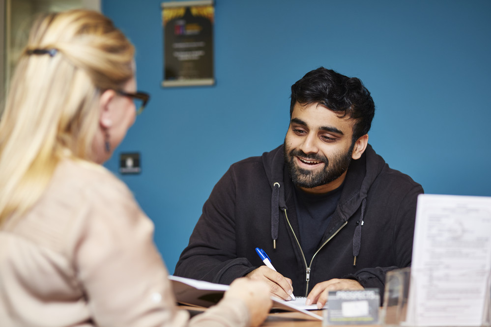 A student receptionist at careers talking to a customer