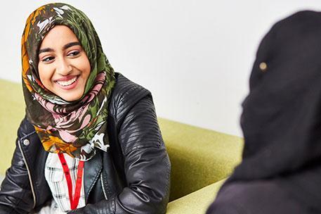 A female student in the Atrium laughing and smiling.