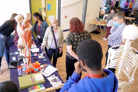 People gathered round a stand featuring medical imagery in DHEZ