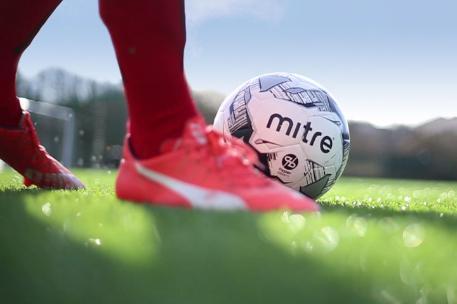 A subject wearing trainers kicking a ball