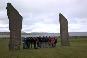 Group picture of excavation team placed in between neolithic stone monuments