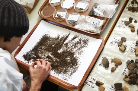 man in lab analysing soil and stones