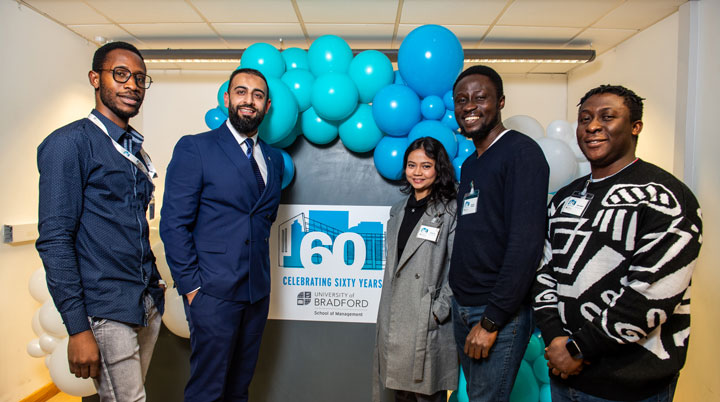 Dr Kamran Mahroof taking a group photo with student attendees at the Annual Management Lecture 2023