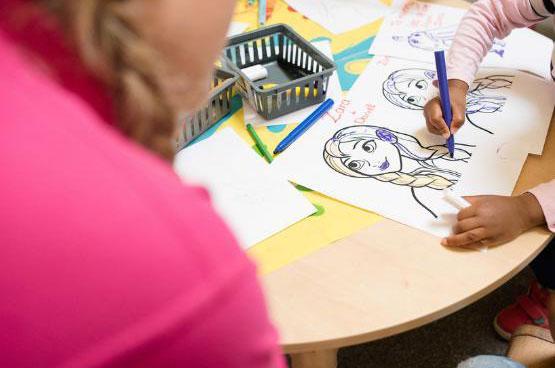 Student and a child colouring some pictures