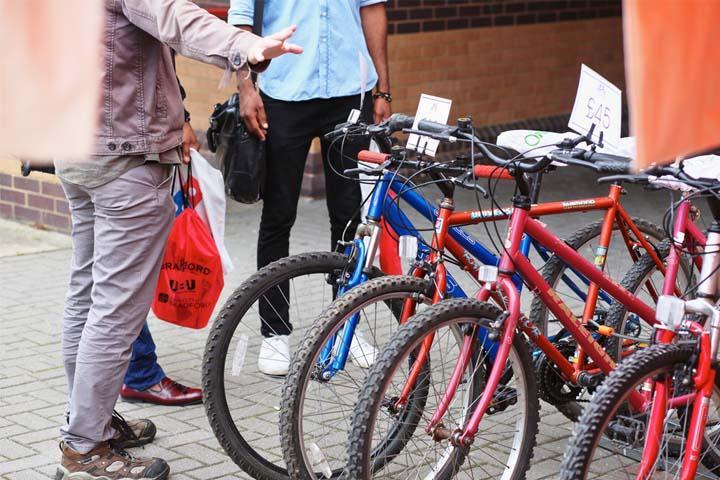 A group of people standing beside a bicycle rack