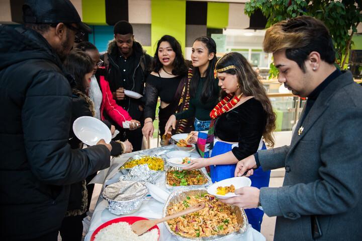 Students dishing out food onto their plates from a buffet table.