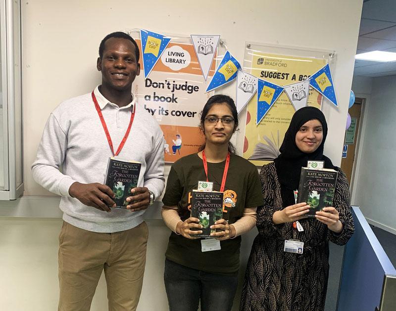 3 students holding books