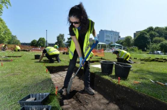 An archaeology student digging on campus