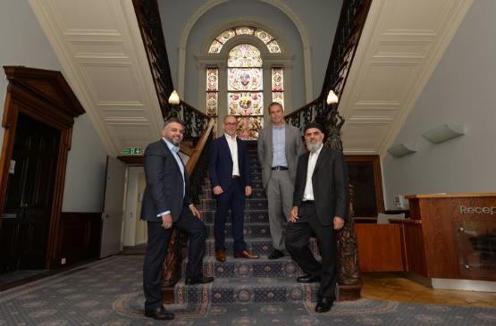 Delegates from Greensville Trust and the University standing inside Emm Lane building following its sale