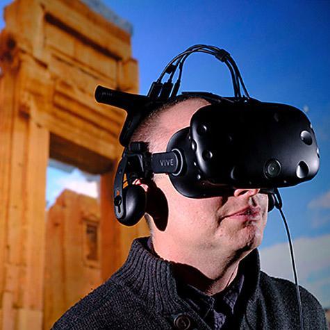 A person wearing a VR headset against a background of an ancient site. 