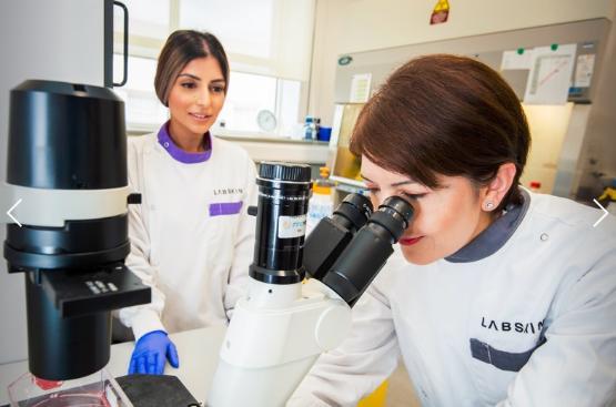 Labskin scientists looking through microscope