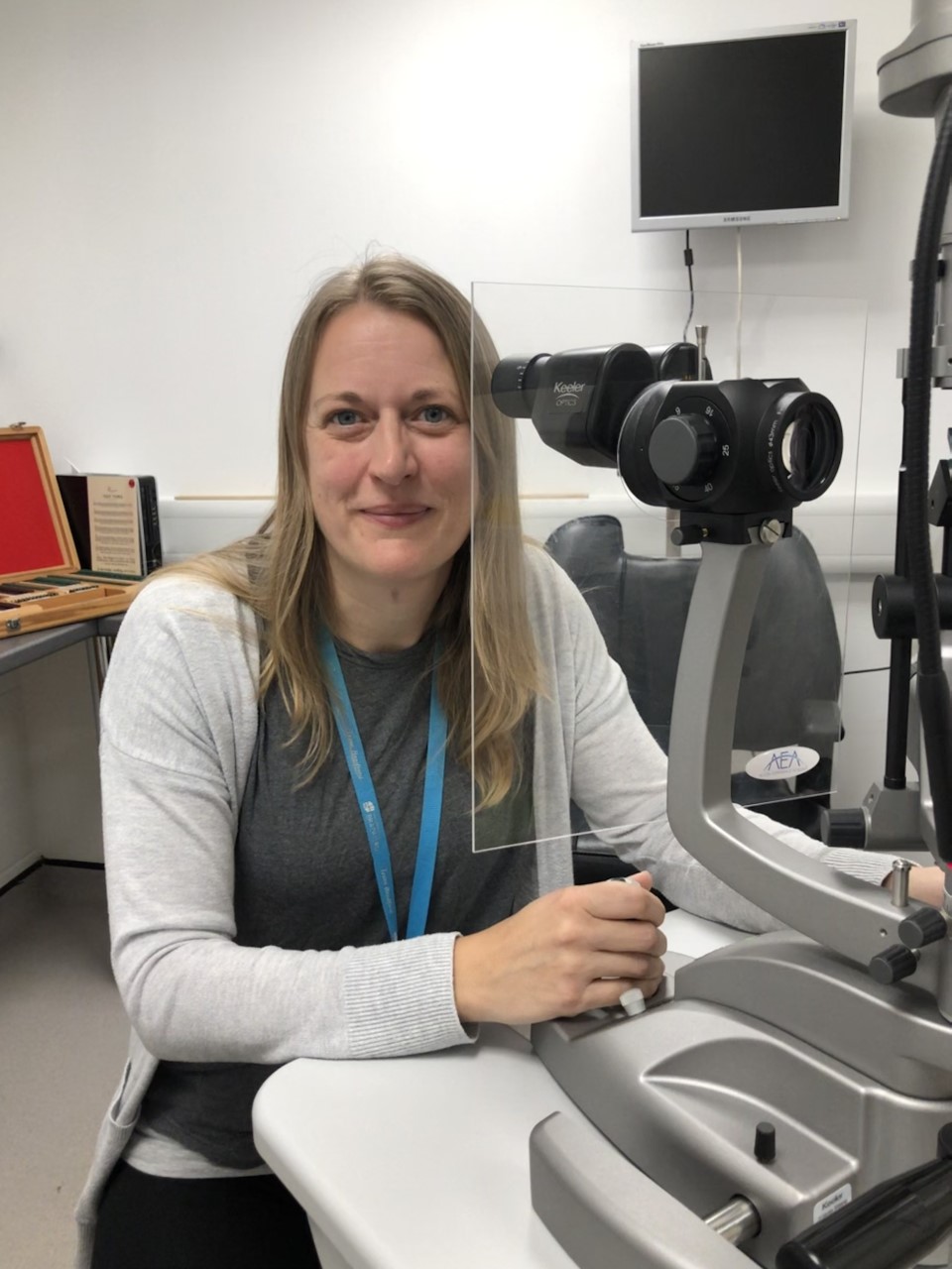 A person sitting at some optometry equipment