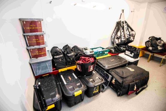 Large bags and boxes full of football kit in a room