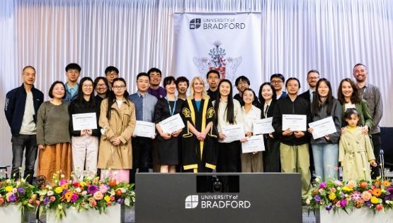 A group of chinese alumni holding certificates in a group