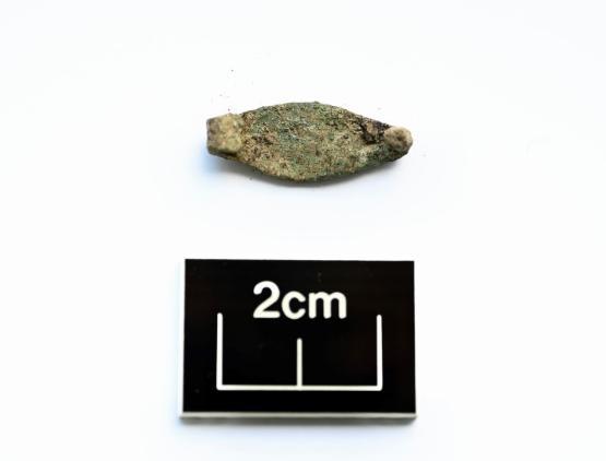 a stone belt buckle found from the Iron Age above a box with two centimetres written in it to donate its size