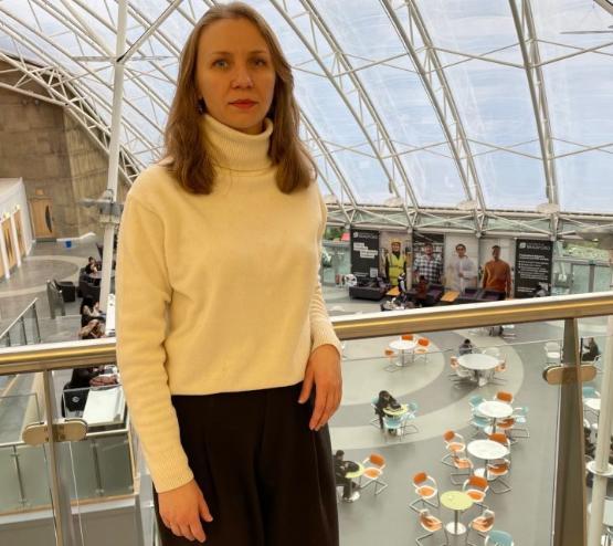 Student stood up next to railing in university atrium building