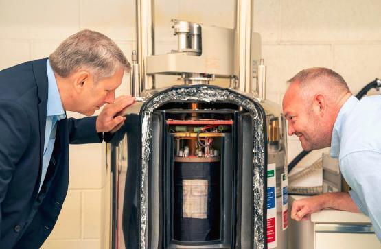 Two academics looking at a nuclear magnetic resonance machine