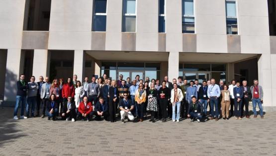 A large photograph of people pose for a group photograph outside a building