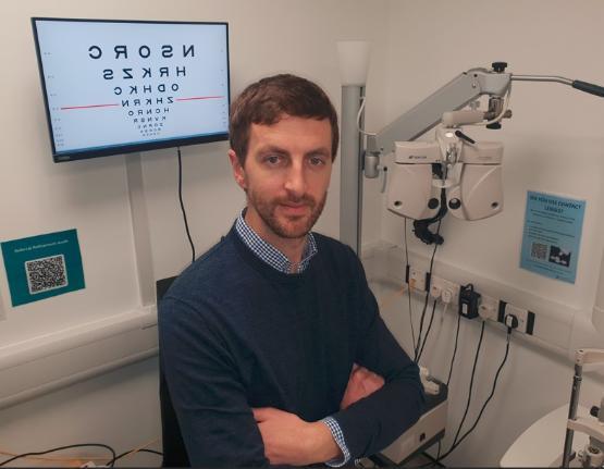 Dr Jonathan Denniss in an opthalmology room surrounded by optometry equipment