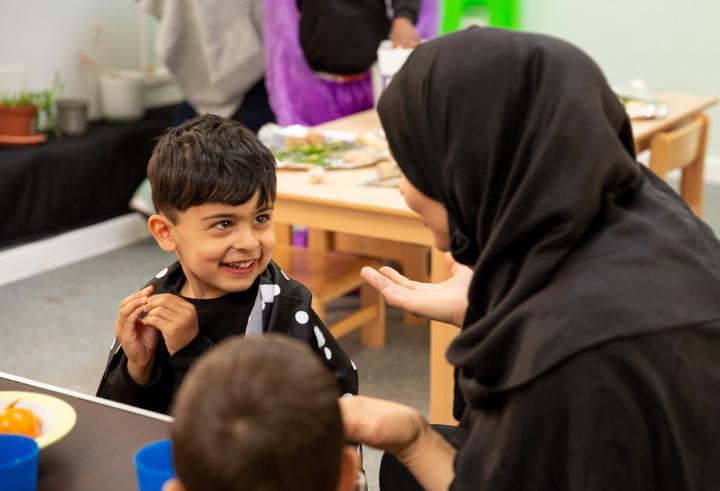 Child smiling with teacher at nursery