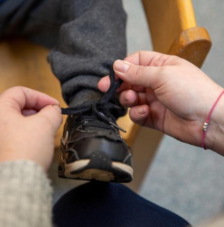 Tying a childs so lace at the Nursery