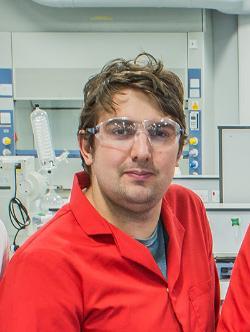 Professor Tom Swift wearing a red lab coat and goggles