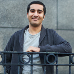 Smiling Bradford alumni leaning on a black railing