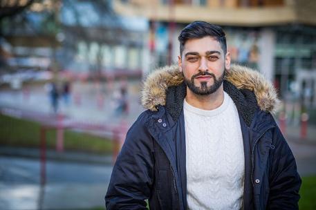 MPAS graduate Mobashar Rashid standing in front of the entrance to Richmond Building