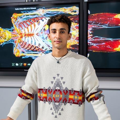 A student standing behind the anatomague table.