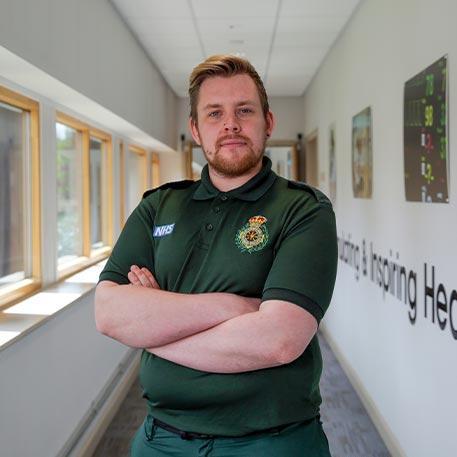 A student paramedic smiling at the camera.