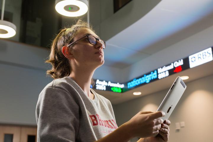 A female student with a ticker in the background.