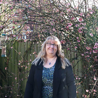 MSc Advanced Dementia Studies student Sarah standing in her garden