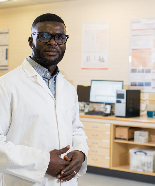 A postgraduate student standing in a biomedical engineering lab