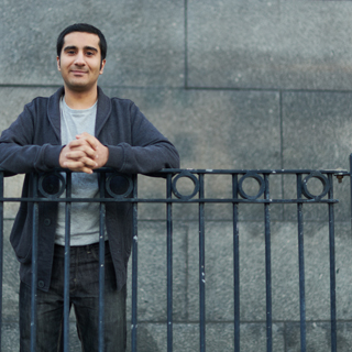 Student smiling whilst leaning on a black railing