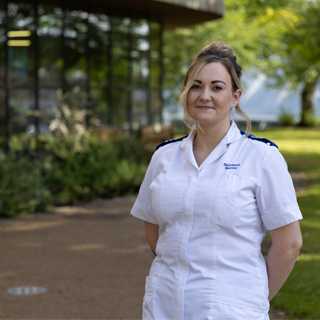 Child Nursing student, Demi-Jo, in uniform stood in front of the Health Studies building