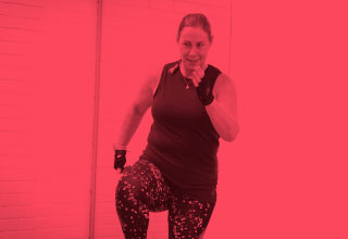 Woman leading body blast class. 